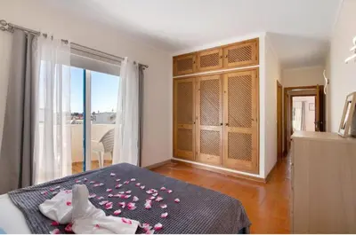 a bedroom with a bed with pink flowers on it at Alta Oura in Albufeira