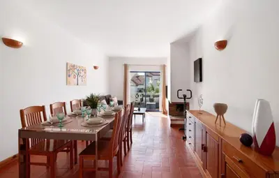 a kitchen and dining room with a table and chairs at Alta Oura in Albufeira