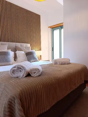 a bedroom with a large bed with towels on it at Marina 3B 1B By AL in Albufeira