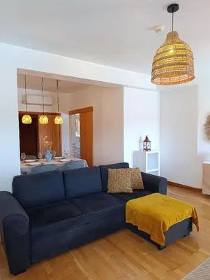 a living room with a blue couch with a yellow blanket at Marina 3B 1B By AL in Albufeira