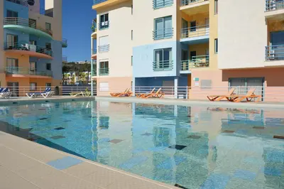 a swimming pool in front of some apartment buildings at Marina 3B 1B By AL in Albufeira