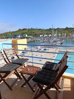 a patio with two chairs and a table next to a pool at Marina 3B 1B By AL in Albufeira