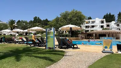 a swimming pool with a palm tree in the middle at Superior Apartment 361 Balaia Golf Village in Olhos de Água