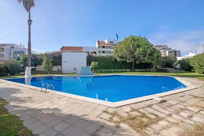 a large blue swimming pool in a yard at Apartament Dita in Albufeira