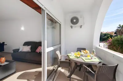 a small balcony with a table and chairs and a couch at Apartament Dita in Albufeira