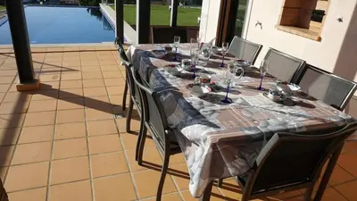 a long table with chairs and wine glasses on it at Luxury 3 Bedroom, 3 ensuits, Private pool, Vale do Lobo in Loulé