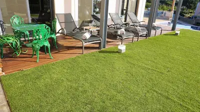 a group of chairs and chairs on a porch with grass at Luxury 3 Bedroom, 3 ensuits, Private pool, Vale do Lobo in Loulé