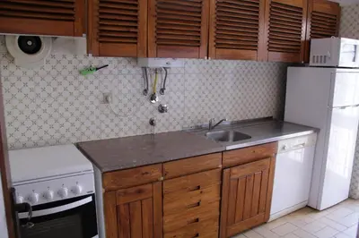 a kitchen with a sink and a white refrigerator at Apart. Barracuda in Vilamoura