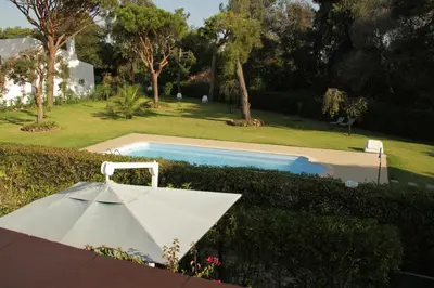 a white umbrella sitting next to a swimming pool at Apart. Barracuda in Vilamoura