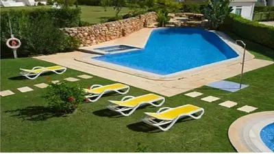 a group of lawn chairs and a swimming pool at Vilamoura - Apartment near Mariana & Falesia Beach in Quarteira