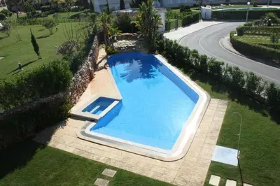 an overhead view of a large blue swimming pool at Vilamoura - Apartment near Mariana & Falesia Beach in Quarteira
