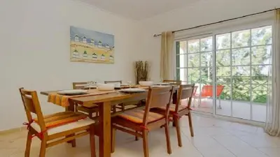 a dining room with a table and chairs and a window at Vilamoura - Apartment near Mariana & Falesia Beach in Quarteira