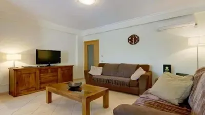 a living room with a couch and a tv at Vilamoura - Apartment near Mariana & Falesia Beach in Quarteira