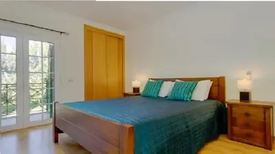 a bedroom with a bed with green and white pillows at Vilamoura - Apartment near Mariana & Falesia Beach in Quarteira