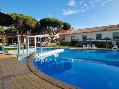 a swimming pool with blue water in front of a building at Oasis Apartment in Albufeira