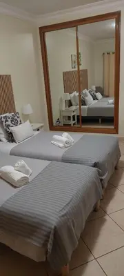 two beds in a room with a mirror at Oasis Apartment in Albufeira