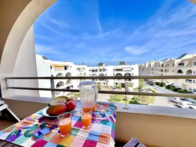 a table with fruit and drinks on a balcony at Albufeira Salgados Beach 6 by Homing in Albufeira