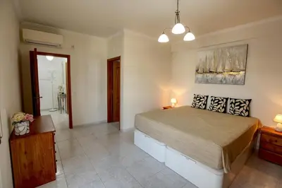 a bedroom with a large bed in a room at Quarteira Apartment with views in Quarteira