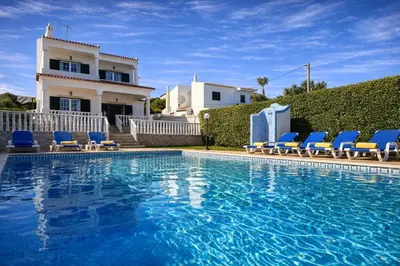 a swimming pool with blue chairs and a house at Casa do Algarve by Check-in Portugal in Albufeira