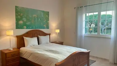 a bedroom with a bed with two lamps and a window at Casa do Algarve by Check-in Portugal in Albufeira