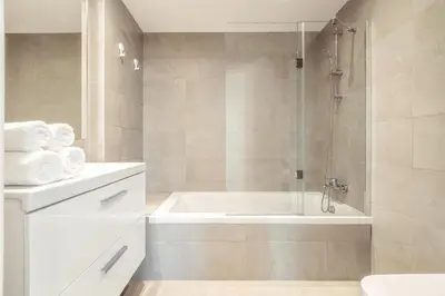 a white bathroom with a tub and a shower at Albufeira Green Dream Pool, Balcony & BBQ in Albufeira