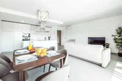a kitchen and living room with a table and chairs at Albufeira Green Dream Pool, Balcony & BBQ in Albufeira