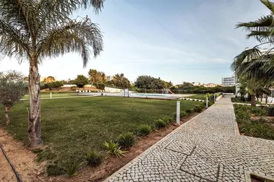 a park with a palm tree and a walkway at Albufeira Green Dream Pool, Balcony & BBQ in Albufeira