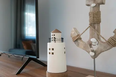 a lighthouse toy on a table next to a mirror at Mello Apartamento renovado, praia de Quarteira in Quarteira