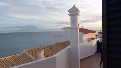 two beds in a white room with a lamp at Al Mare Ocean View in Albufeira