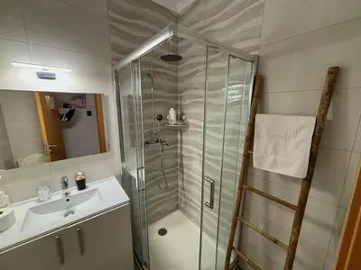 a glass shower in the middle of a room at Al Mare Ocean View in Albufeira