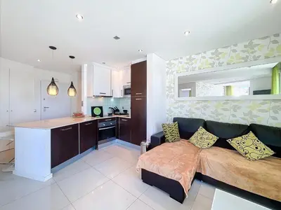 a living room with a couch and a kitchen at Paradise Near Old Town in Albufeira