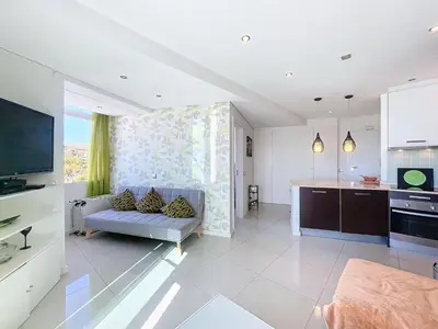 a living room with a couch and a kitchen at Paradise Near Old Town in Albufeira