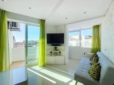 a living room with a blue couch and a tv at Paradise Near Old Town in Albufeira