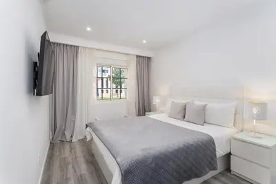 a white bedroom with a bed and a window at Casa dos Avós - Faro Relax & Comfort in Faro