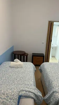 a bedroom with two beds and a table and a window at Sweet Dreams in Albufeira