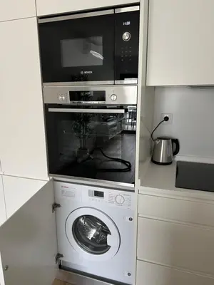 a microwave and a washing machine in a kitchen at Appartement T1 Faro in Faro