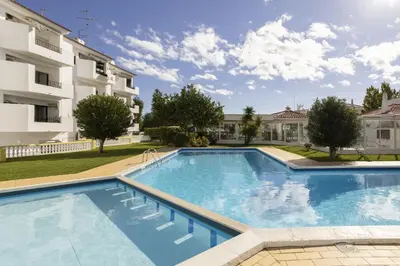 a large swimming pool in front of a building at Areias de São João 2BR Apartment - Shared Pool & Terrace, by Hopstays in Albufeira