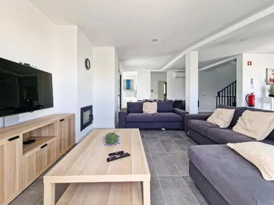 a living room with two purple couches and a tv at Villa Soares - Centro Albufeira - For Families - BY BEDZY in Albufeira