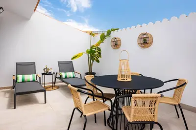 a patio with a black table and chairs at Roots Apartments in Faro