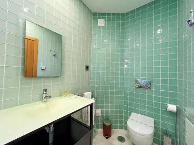a bathroom with a toilet and a sink and a mirror at Luxury 4-Suite Villa, Pool, Jacuzzi, Games Room in Albufeira