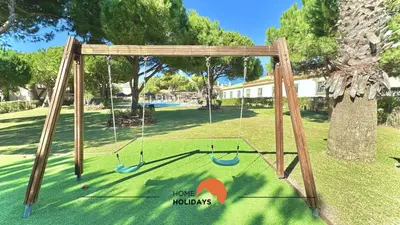 a swing set with two swings in a yard at #269 T2 Bicos Flat R by Home Holidays in Albufeira