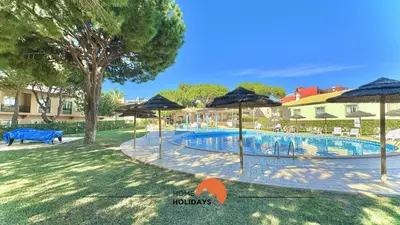 a swimming pool with umbrellas in a yard at #270 T2 Bicos Flat S by Home Holidays in Albufeira