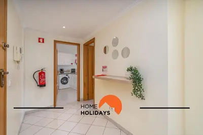 a hallway of a house with a kitchen and have holidays sign on the wall at #273 T2 Bicos Flat M by Home Holidays in Albufeira