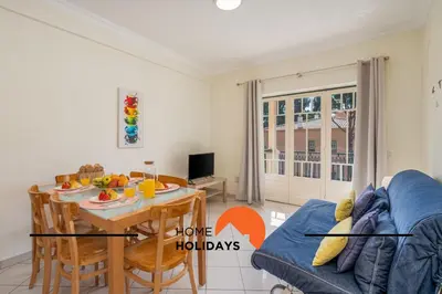 a living room with a table and a blue couch at #273 T2 Bicos Flat M by Home Holidays in Albufeira