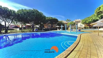 a large swimming pool with a sign that says have holidays at #273 T2 Bicos Flat M by Home Holidays in Albufeira