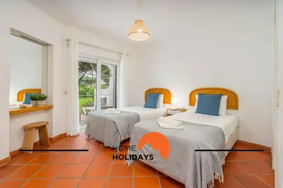 two beds in a room with two tables at #250 Apartamento 264 by Home Holidays in Albufeira