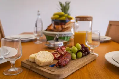 a table with a plate of food and glasses of wine at Marina Orada Apartment with Pool - 900m from the Beach in Albufeira
