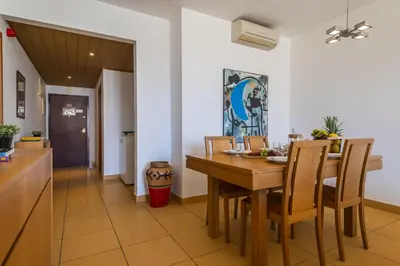 a kitchen and dining room with a wooden table and chairs at Marina Orada Apartment with Pool - 900m from the Beach in Albufeira