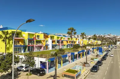 a row of colorful houses on a city street at Marina Orada Apartment with Pool - 900m from the Beach in Albufeira