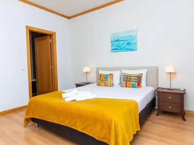 a bedroom with a large bed with a yellow blanket at Sunshine House by Stay ici Algarve Holiday Rental in Albufeira